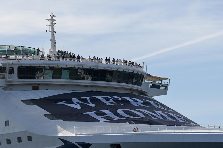 Close up of P&O cruise ship Pacific Explorer as it enters Sydney Harbour with a banner 'we're home' on it.