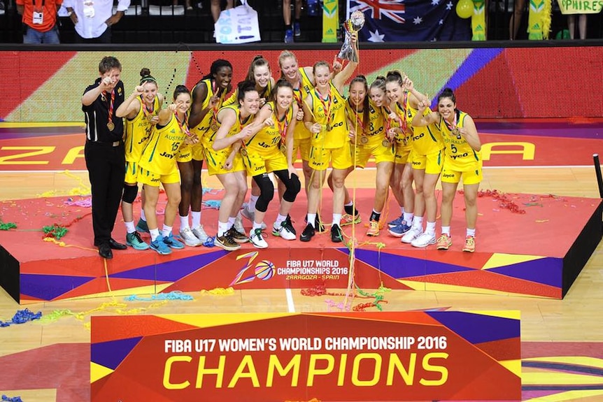 A group of women wearing yellow and green uniforms posing for a photo while holding a trophy. 