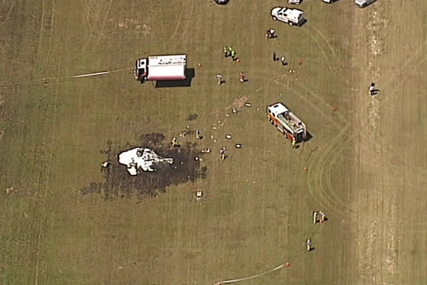 An aerial shot of a plane clash with firetrucks on the scene.