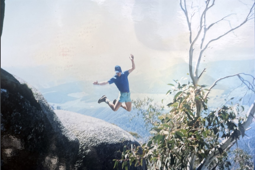 Figure of a young man jumping off a rock and posing mid-air