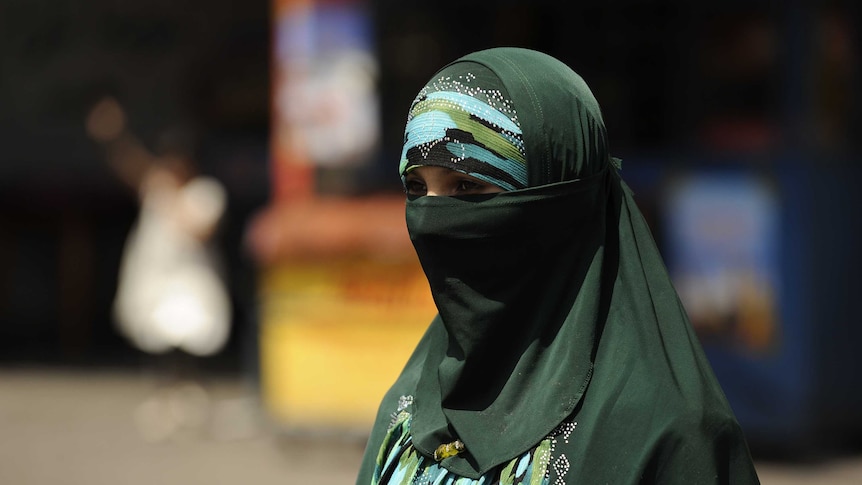 A Muslim ethnic Uighur woman walks in Urumqi, capital of China's Xinjiang region