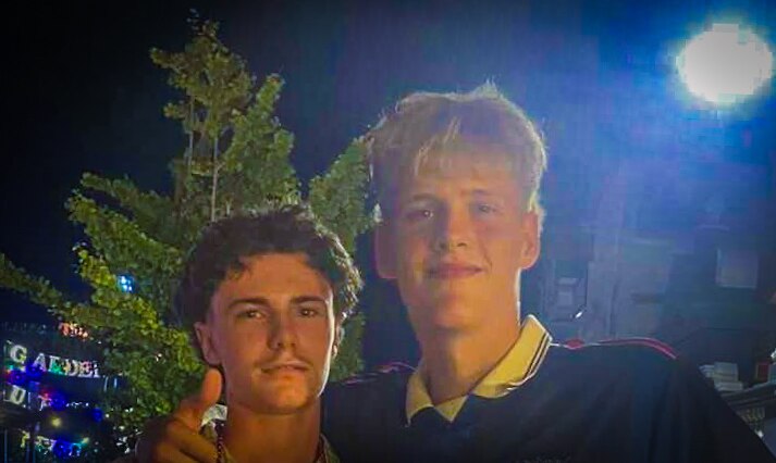 A photo of two teenage boys looking at the camera.