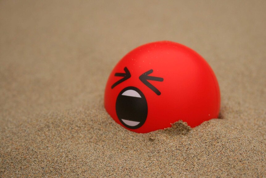 A stress ball lies in angst in the desert.