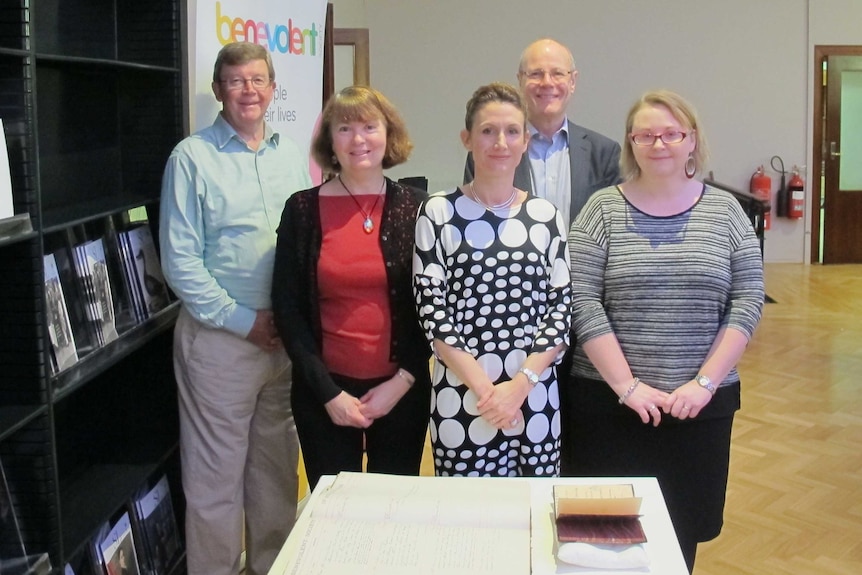 Dr Tanya Evans (centre) with family historians and some of the records of The Benevolent Society.