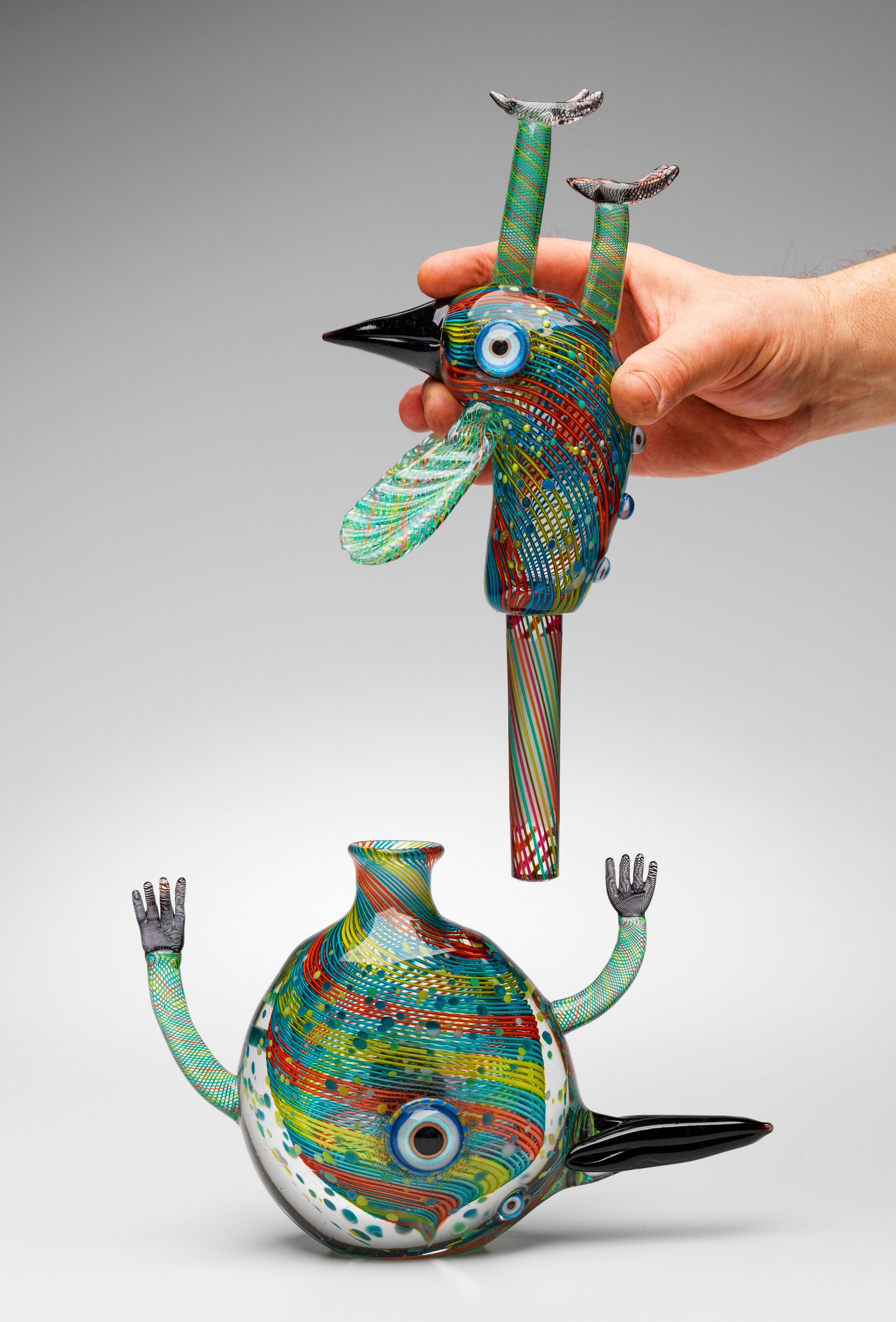 A sculpture by artist Tim Moore, it shows a bird-like creature made out of glass, filled with colourful line-work