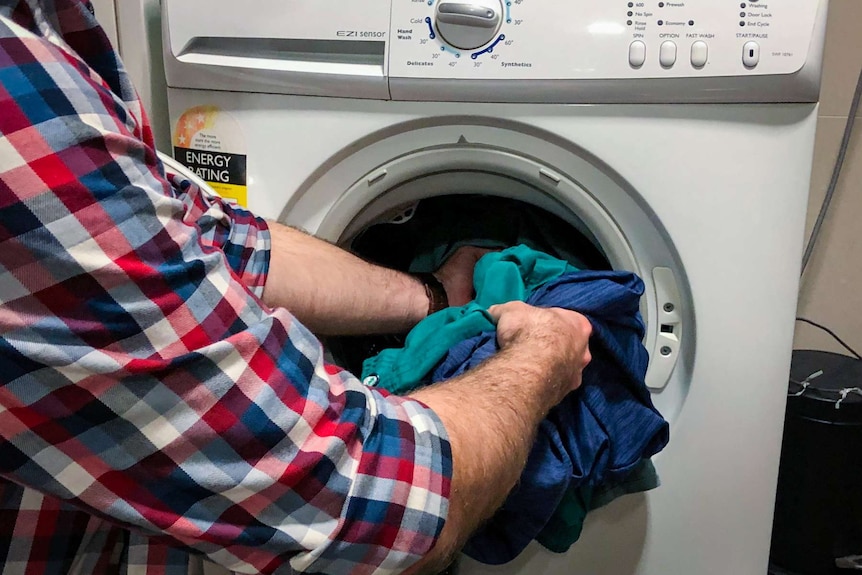 Man loading a washing machine.