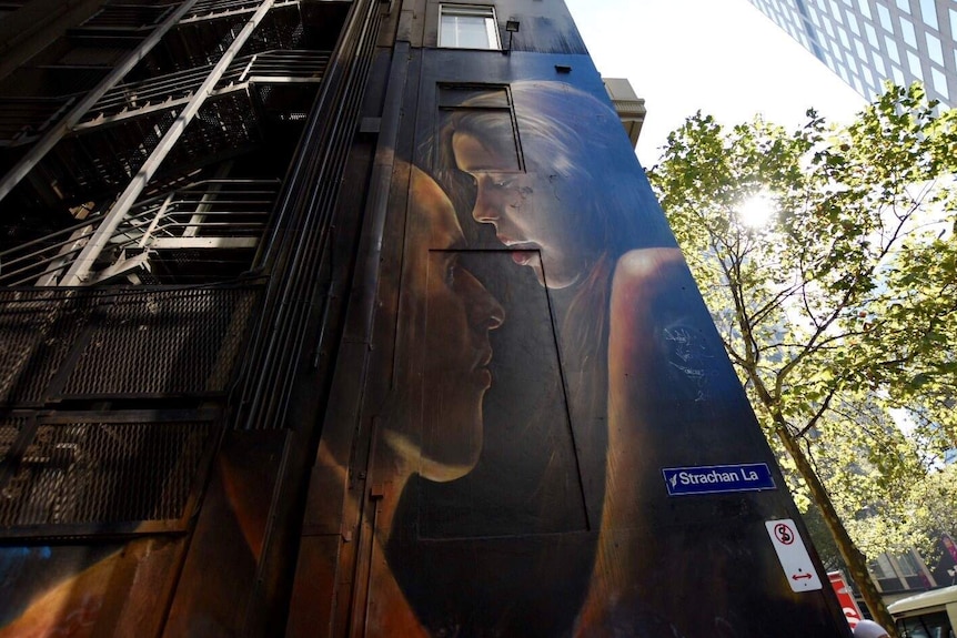 A painting of a man and a woman on the side of a building in Strachan Lane.