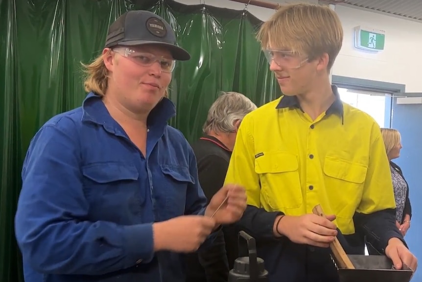 Two students in a high school metalwork shop.