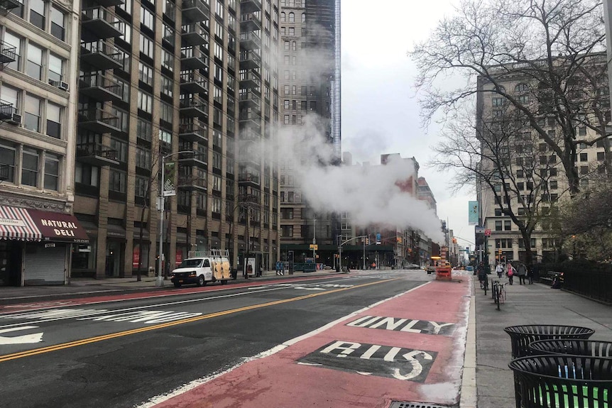 Smoke rises in the air on a near-deserted street in New York.