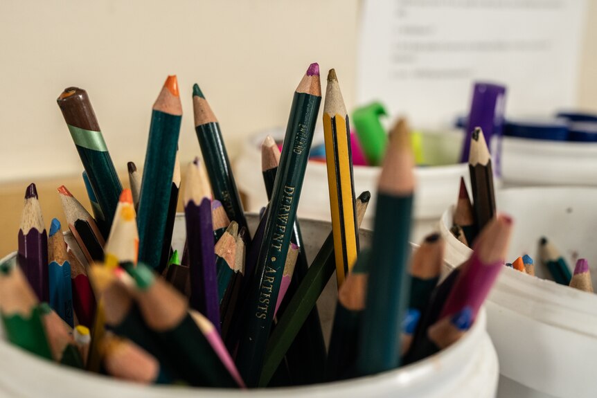 A close up of coloured pencils in a bucket.