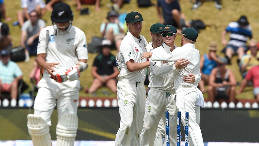 Australian captain Steve Smith (R) looks on as players celebrate a first Test win over New Zealand.