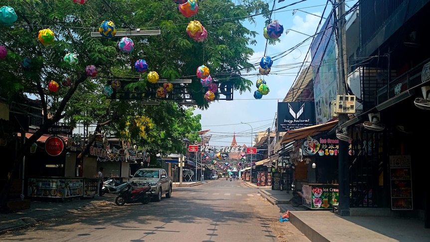 Colourful decorations and signage adorn an empty entertainment district.