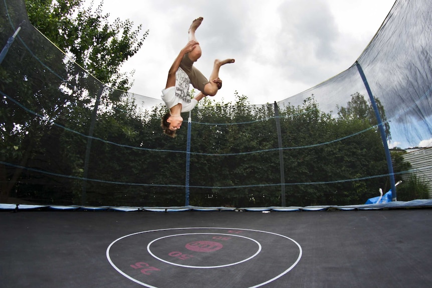 Teenager jumping on trampoline generic