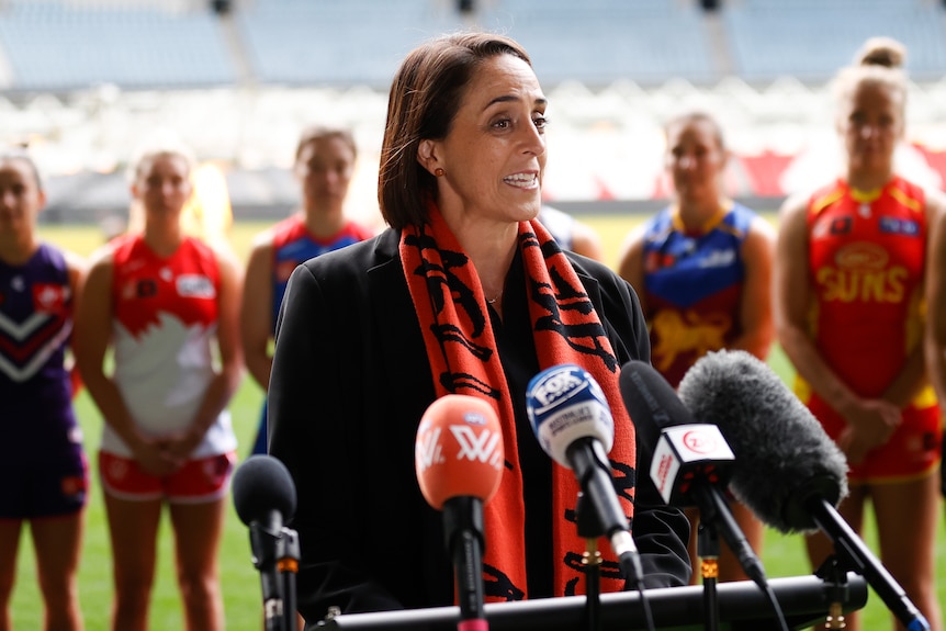 Nicole Livingstone addresses the media in front of a range of AFLW captains at Marvel Stadium