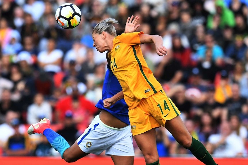 Alanna Kennedy and Cristiane Rozeira de Souza both in the air looking to head the ball.