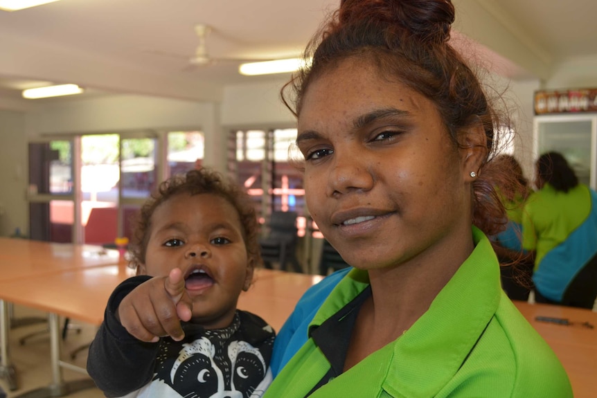 Corrin Walden holding her son Akaydeia Walden, who is pointing at the camera