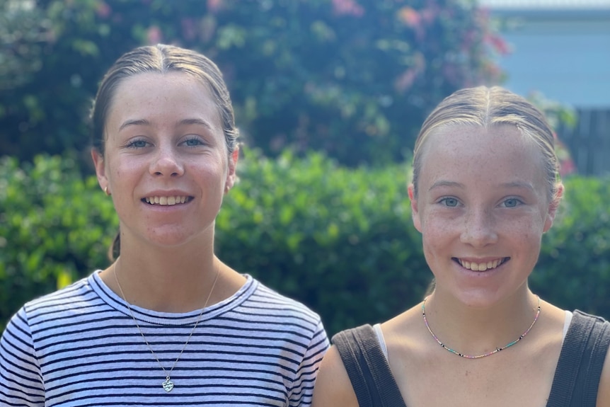 Two young girls smile at the camera