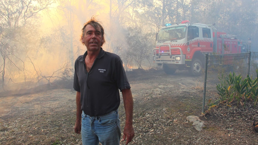 A man in front of a fire