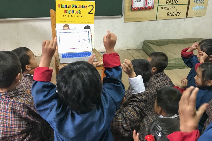 Young school children in Bhutan study English letter.