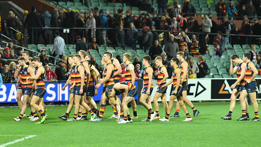 Adelaide Crows players walk off the field after Swans loss