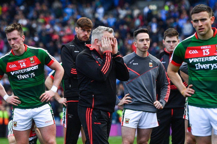 A group of despondent Mayo players and coaches stand around after losing to Dublin in the 2017 All-Ireland final.