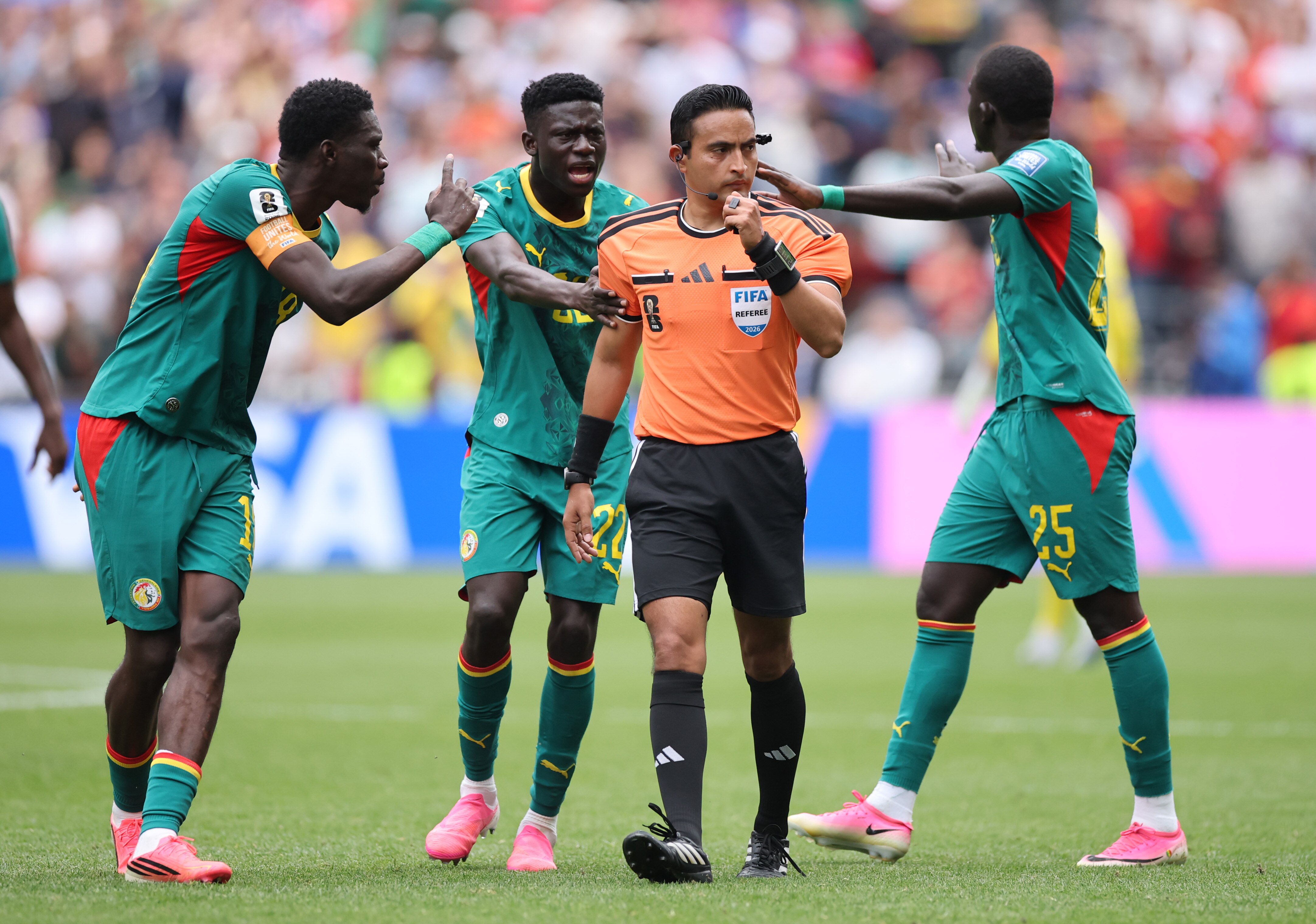 Senegal players crowd the ref to complain about a penalty decision