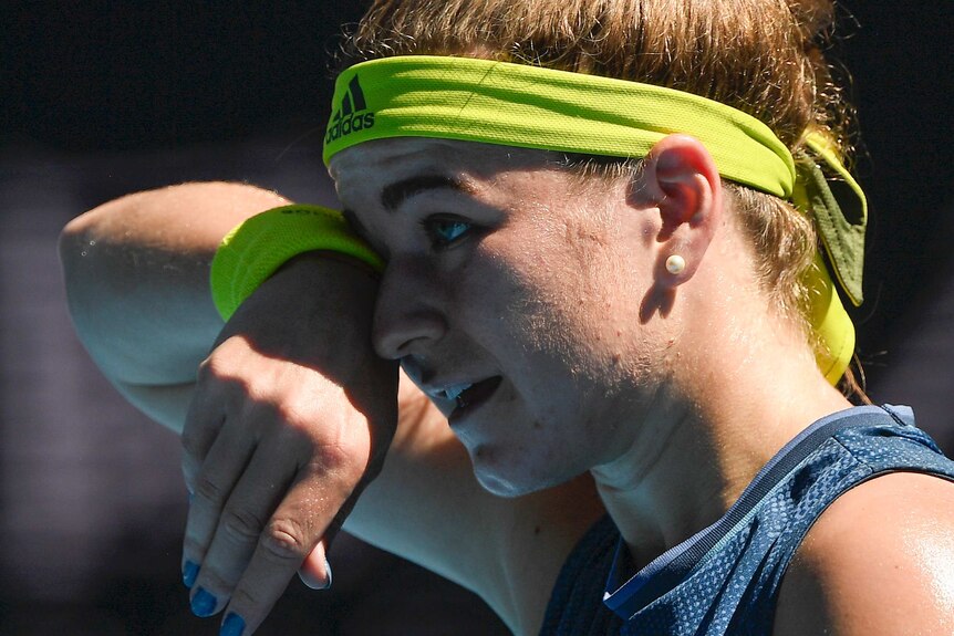 Karolína Muchová wipes her forehead with her wrist band