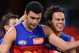 Brisbane Lions AFL players celebrate in a group after a goal was kicked against Essendon.