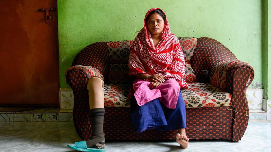 Rana Plaza collapse survivor Sumi Akhter poses for a portrait with her prosthetic leg at her residence. 