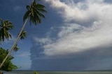 Smoke from the Mount Tavurvur volcano rises over water.