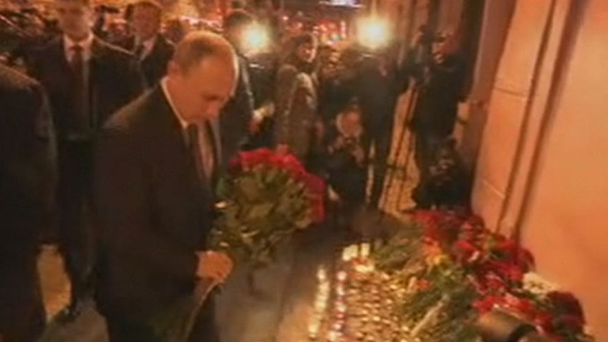Russian President Vladimir Putin offers a floral tribute to victims of the train blast