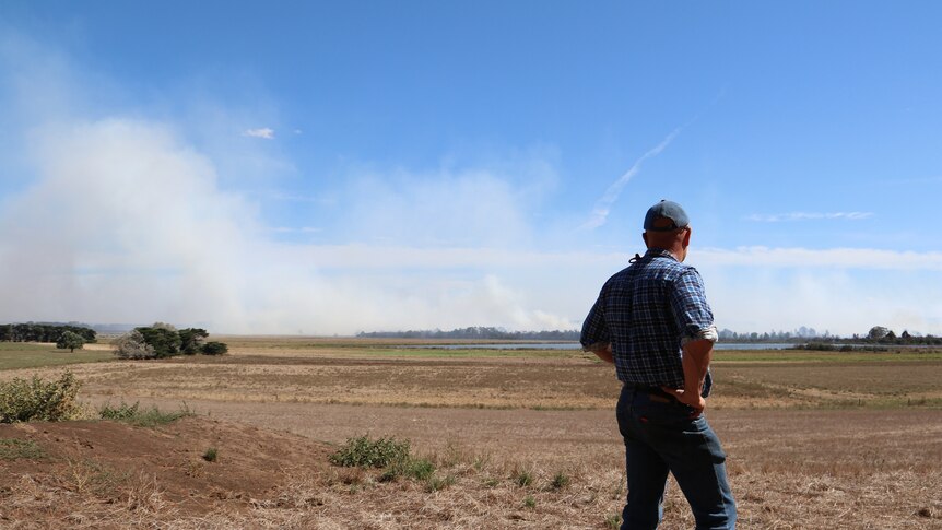 farmer surveys the long-burning peat fires that are producing toxic smoke