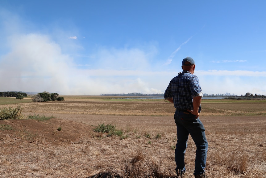 farmer surveys the long-burning peat fires that are producing toxic smoke