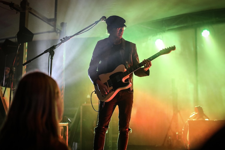 Glenn Sarangapany from Birds of Tokyo playing guitar at a concert.