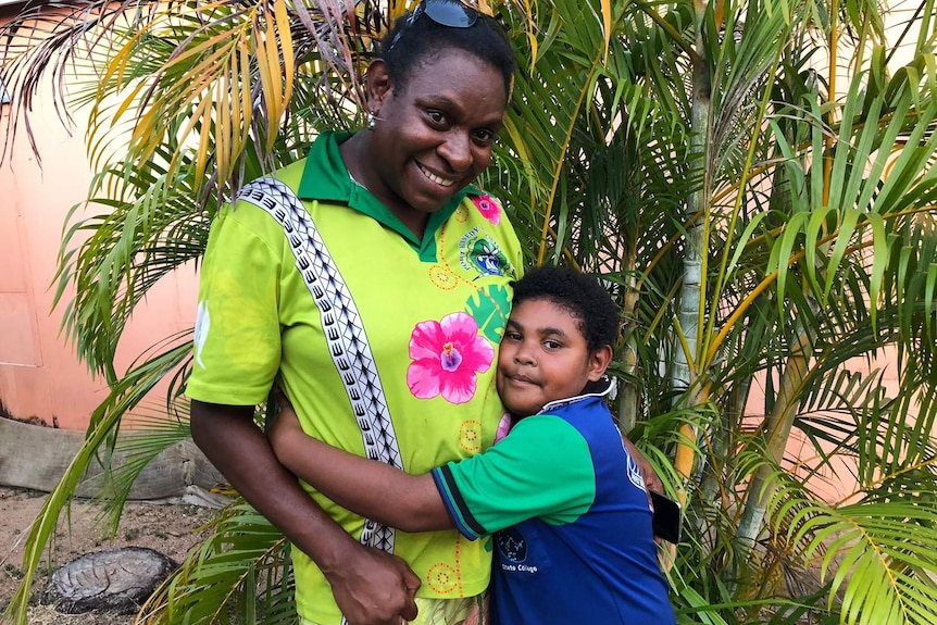 Seven-year-old Patricia gives her mother, Margaret Gibia, a hug.