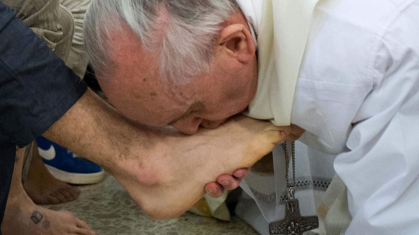 Francis kisses the feet of a prisoner after washing them at a mass in Rome.
