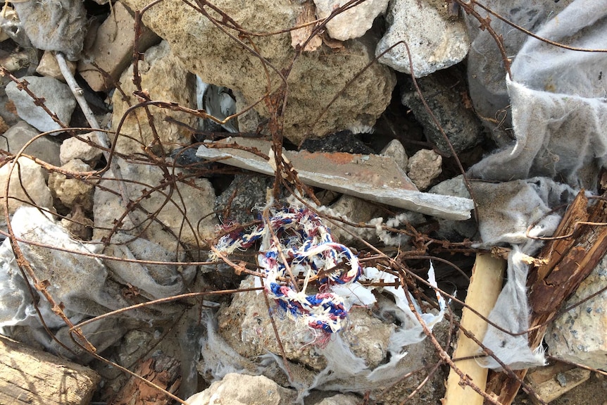 Pieces of fractured pipe on the groyne, amongst a pile of rusted wire and other rubble.