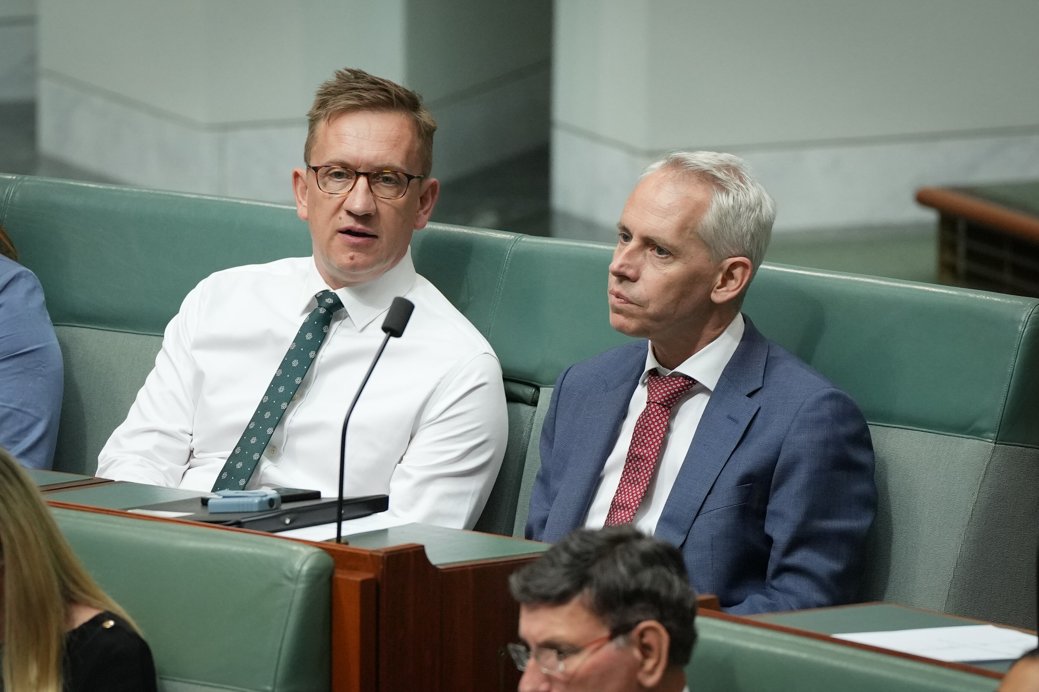 Julian Hill wearing a green tie and glasses. 