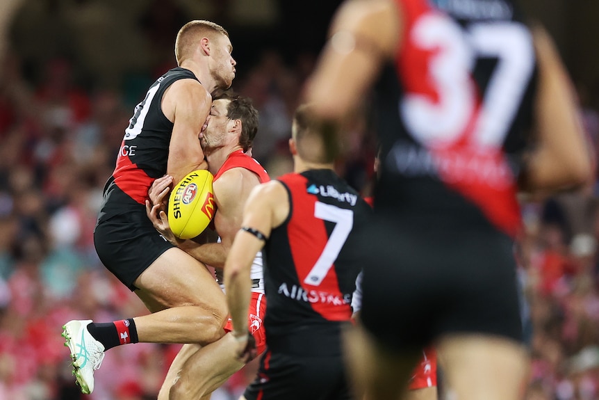Essendon's Peter Wright hits Sydney's Harry Cunningham in the face.