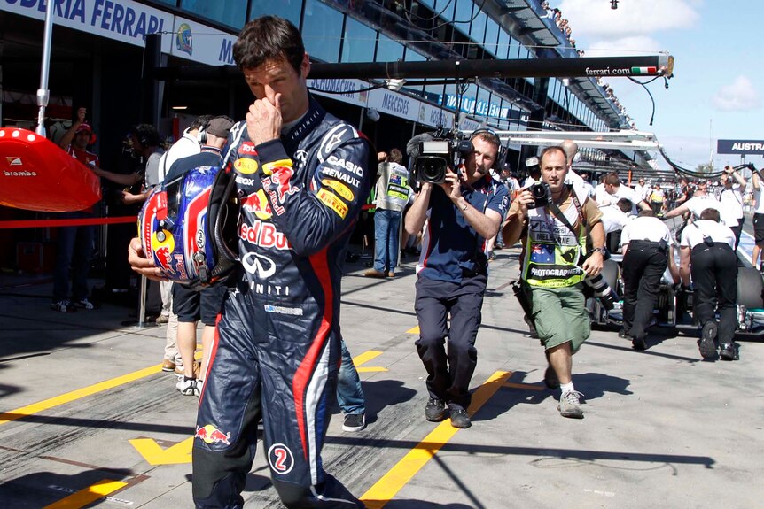 Red Bull driver Mark Webber walks in the pit lane