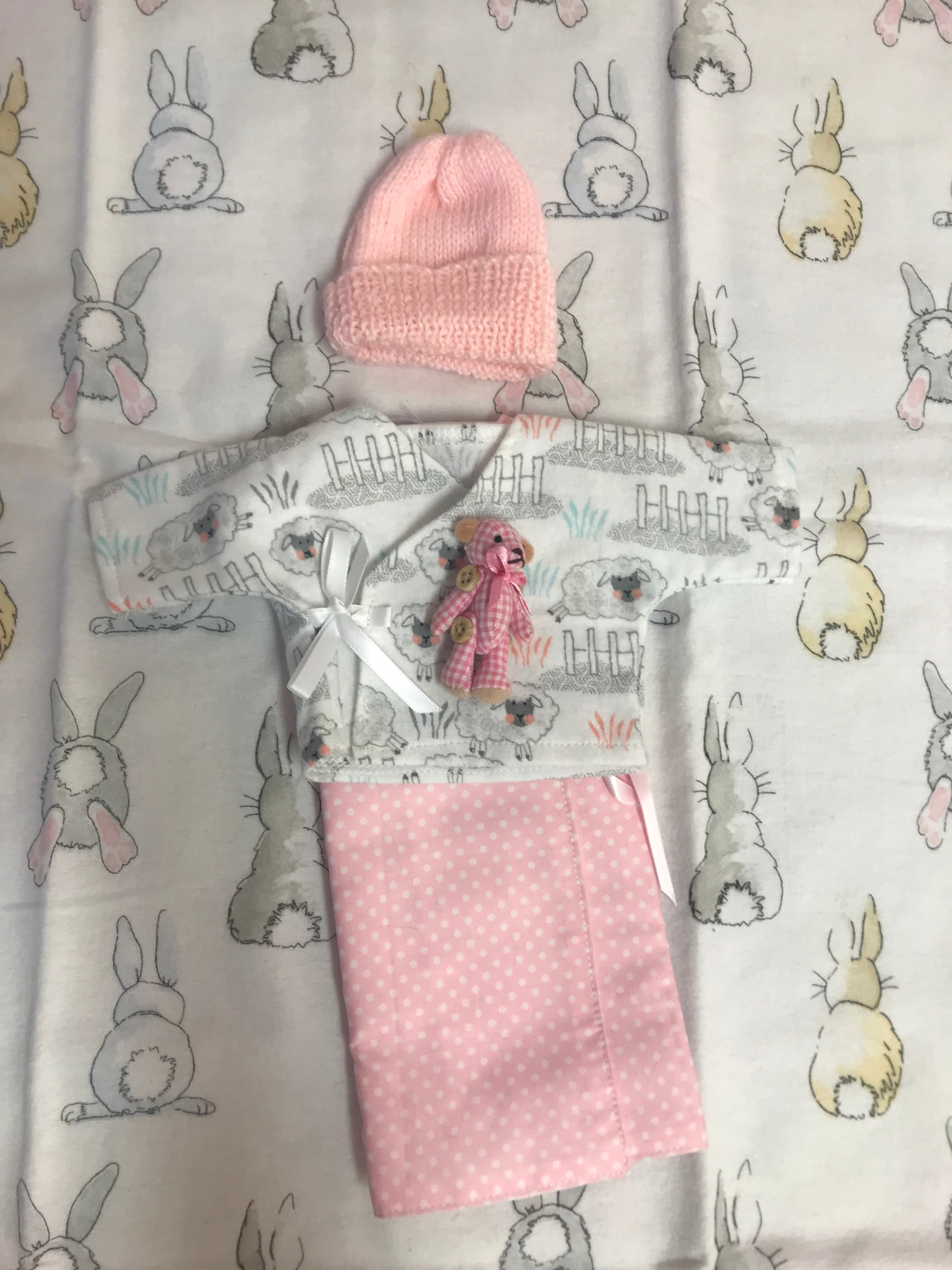 An arrangement of small white and pink baby clothes 