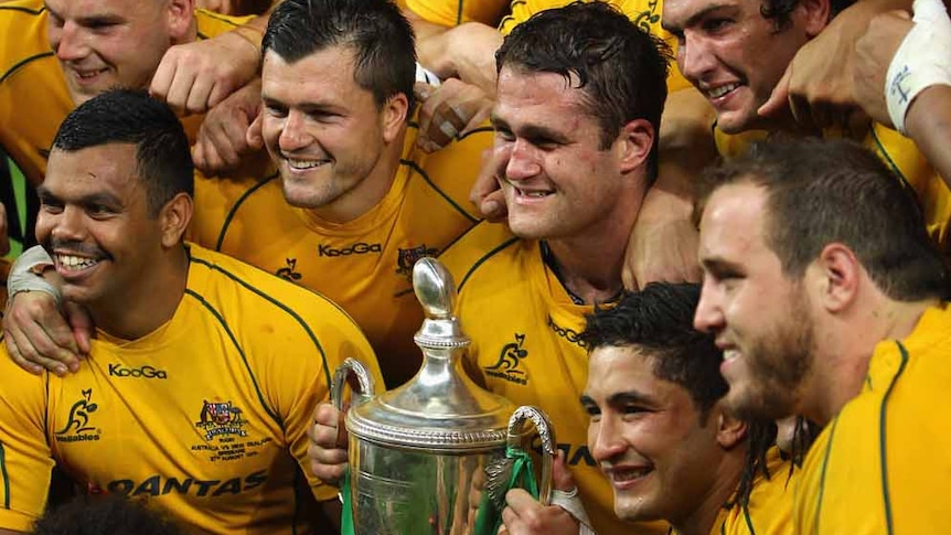Champions ... James Horwill lifts the trophy on his first match as Wallabies captain after Australia broke its Tri Nations drought.