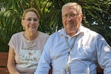 Cheryl and Simon Clemence sit on a bench.