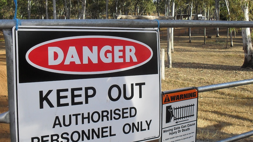 Signs at the quarantined property where a mare died from hendra virus warn of entering the property.