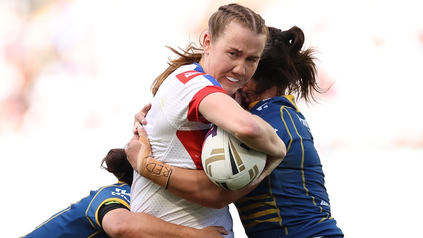 Newcastle Knights' Tamika Upton looks to offload in a tackle by Parramatta Eels in the NRLW grand final.