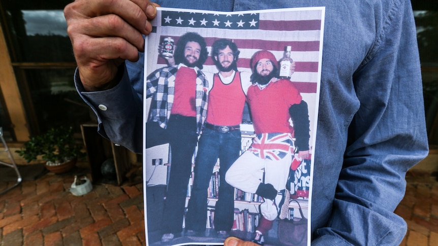 A close up photo of Bill Wiglesworth flanked by two mates at an American Independence Day party.