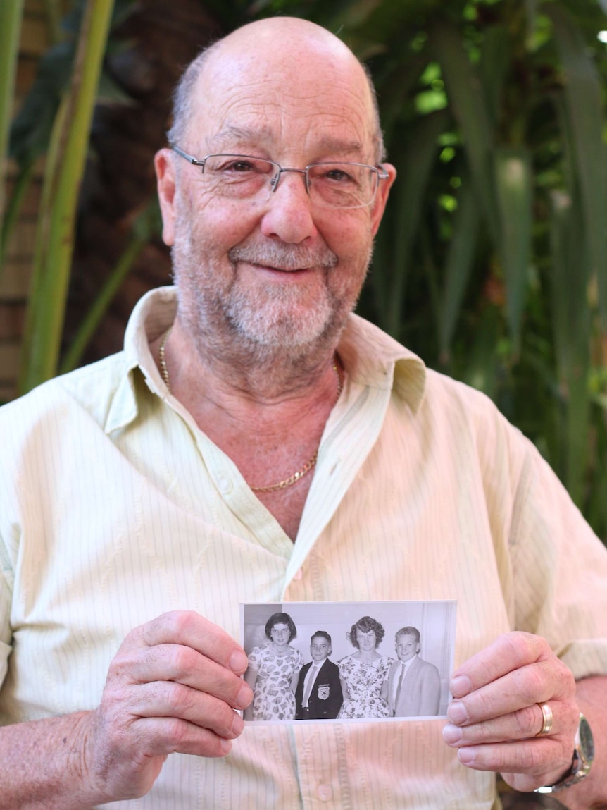 Geoff Higgs holds a photo from his childhood.