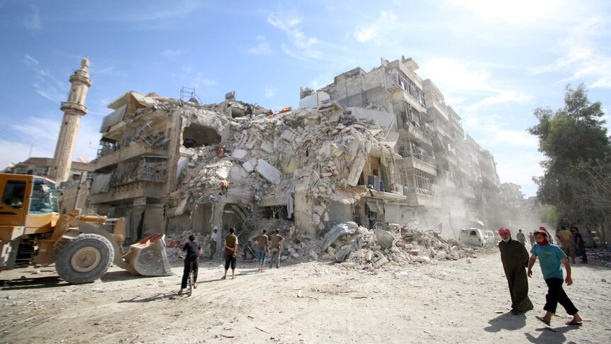 People inspect a damaged site after an air strike.