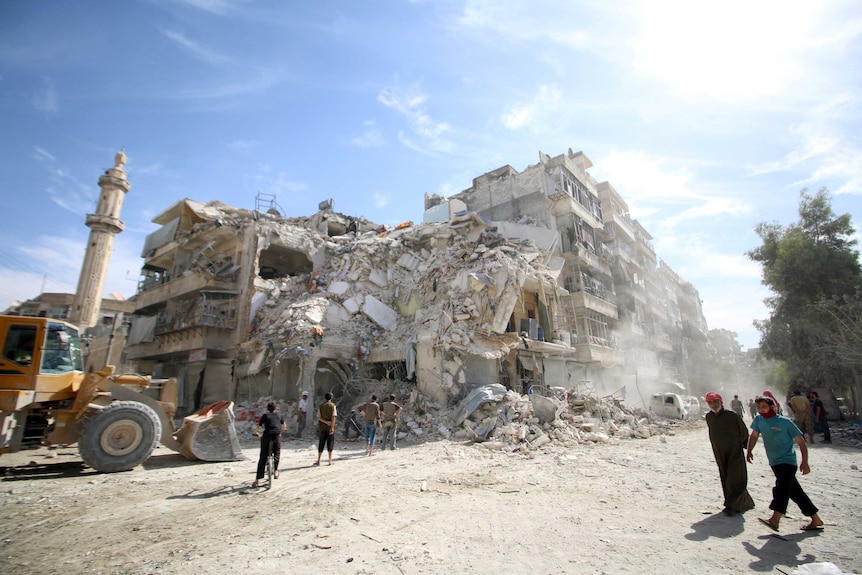 People inspect a damaged site after an air strike.