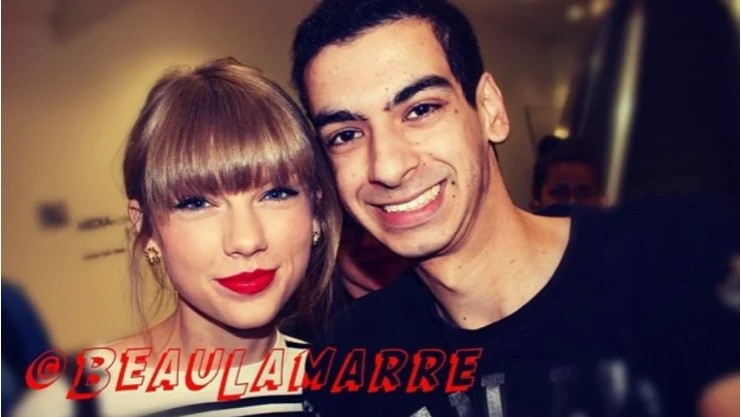Beau Lamarre stands smiling beside celebrity Taylor Swift